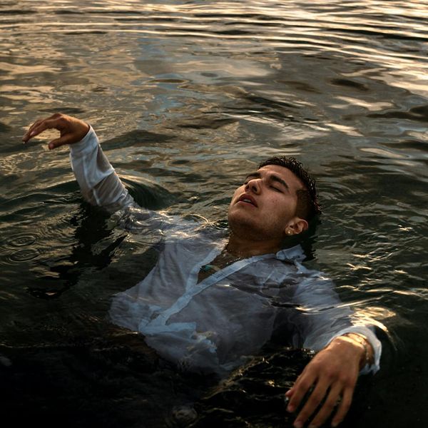 Person meditating peacefully outdoors with a serene natural background.